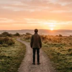 Person looking toward the horizon at sunrise, symbolizing how to forget someone and move on